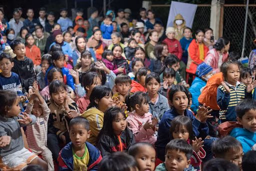 Trẻ em và người dân thôn Cột Buồm háo hức xem chương trình văn nghệ của sinh viên tình nguyện Trường ĐH Bách khoa, ĐH Đà Nẵng biểu diễn.