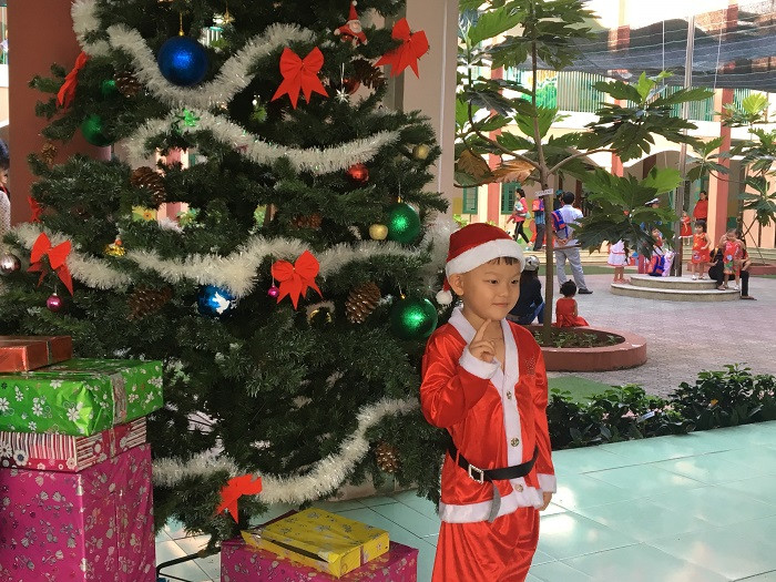 Các em nhỏ rất thích thú khi trường học trang trí cây thông Noel