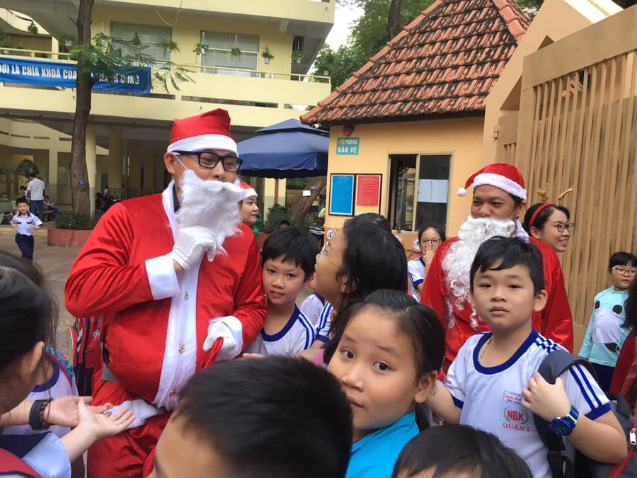 Học sinh Trường TH Nguyễn Bỉnh Khiêm, quận 1, TPHCM thích thú khi có sự xuất hiện của ông già Noel ở cổng trường