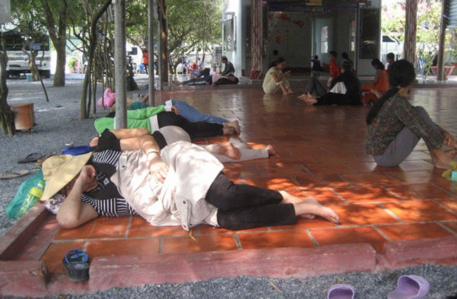 Nhiều người nằm la liệt trên sàn gạch trong "khu vườn kỳ lạ" ở ấp Tân Hội, xã Đức Lập Thượng, huyện Đức Hòa (Long An) ngày mồng 1 Tết. Nhiều người nằm la liệt trên sàn gạch trong