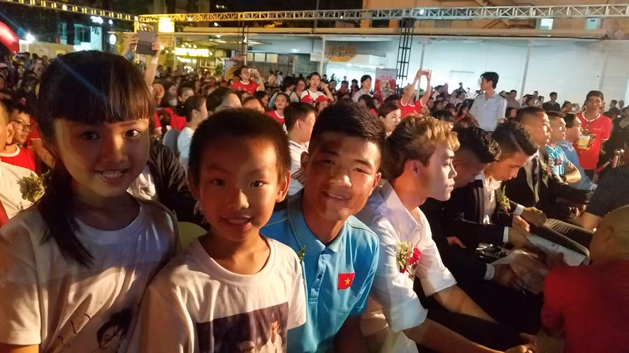 Hai em nhỏ chụp ảnh với cầu thủ Hà Đức Chinh.