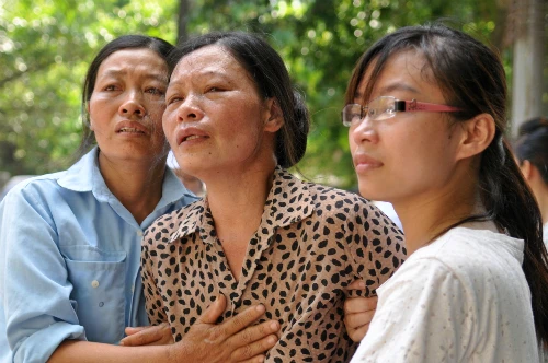 Gia đình những người bị nạn chờ đón thi thể người thân tại khu vực nhà đại thể của Bệnh viện 108. Ảnh: Quý Đoàn. 