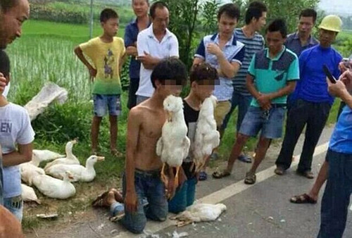 Dân làng bắt hai thiếu niên trộm ăn trộm quỳ xuống dưới sự chứng kiến của những người dân hiếu kỳ xung quanh. Sau đó họ còn bắt thủ phạm ngậm chặt hai con vịt đã chết trong miệng. vn2-JPG-2187-1409391916.jpg