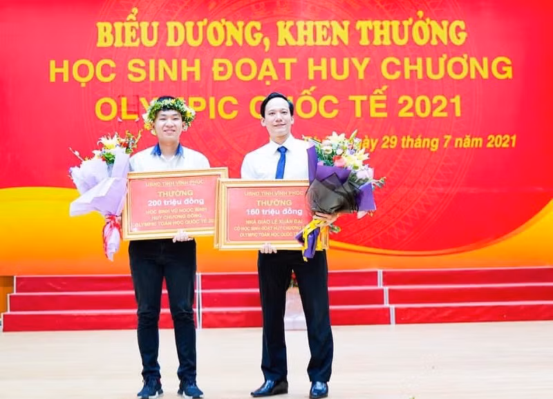 Vũ Ngọc Bình đoạt Huy chương Đồng Olympic Toán quốc tế 2021 nhận phần thưởng 200 triệu đồng và thầy Lê Xuân Đại (phải), Trường THPT chuyên Vĩnh Phúc nhận thưởng 160 triệu. Ảnh: NVCC