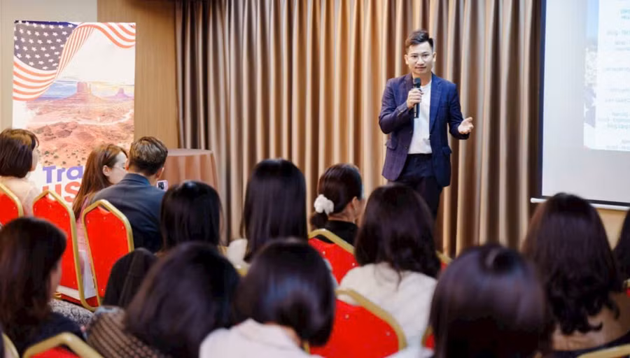 Anh Nguyễn Việt Hoàng trong buổi họp hướng dẫn đoàn làm thủ tục xuất cảnh.