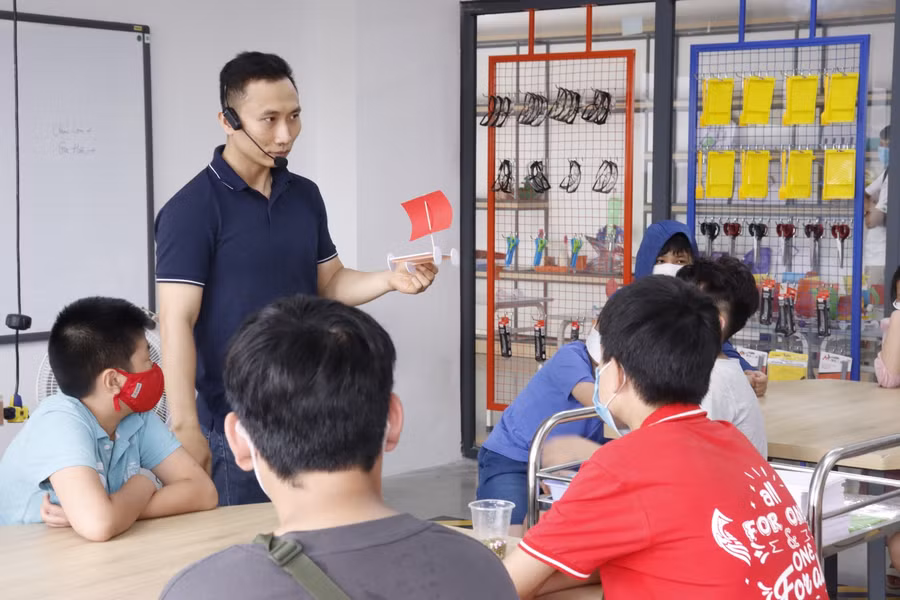 Thầy giáo trẻ Phạm Việt Dũng và học sinh tại Phenikaa School.