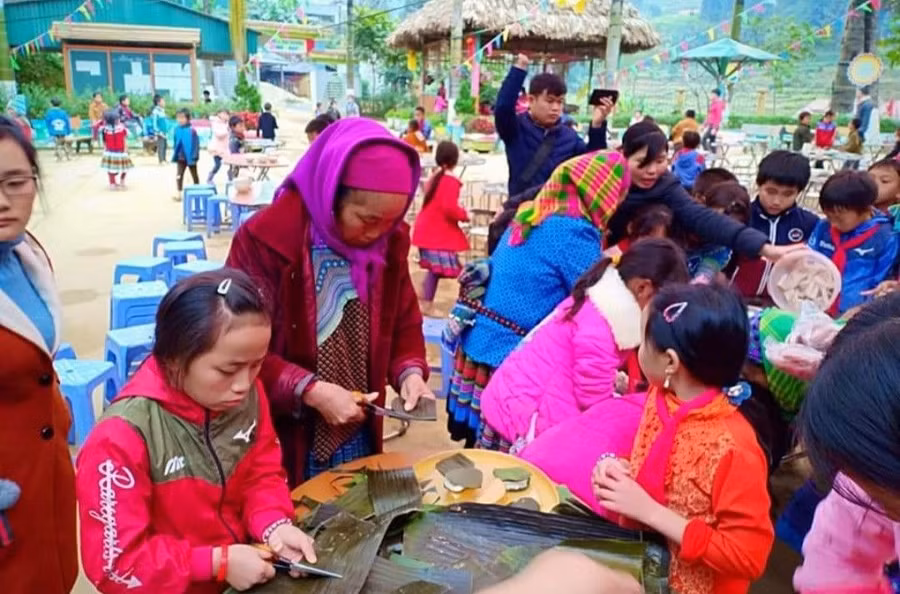 Phụ huynh Trường Tiểu học số 1 xã Sín Chéng (Si Ma Cai, Lào Cai) tham gia làm bánh gây quỹ ủng hộ học sinh nghèo. Ảnh: NTCC