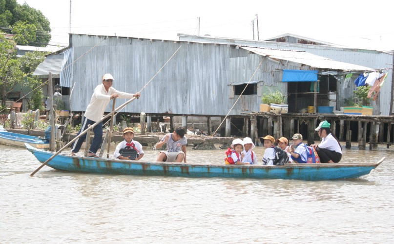 Học sinh huyện Ngọc Hiển (Cà Mau) đến trường bằng đò. Ảnh: Q. Ngữ