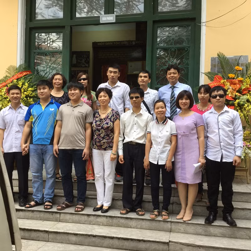 Thầy Phạm Đức Nam (đứng ngoài cùng hàng trên) cùng đoàn Phật tử tặng quà Tết cho HS khiếm thị.