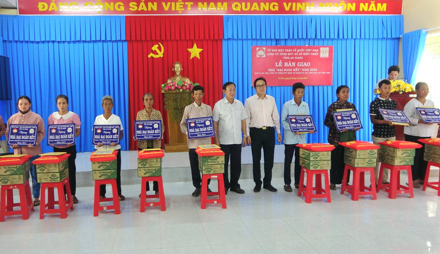 Ông Nguyễn Tiếc Hùng - Chủ tịch Ủy ban MTTQVN tỉnh An Giang và nhà tài trợ trao biểu trưng nhà và tặng quà cho hộ nghèo.