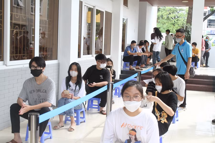 Sinh viên ngồi xếp hàng đợi đến lượt làm thủ tục nhập học