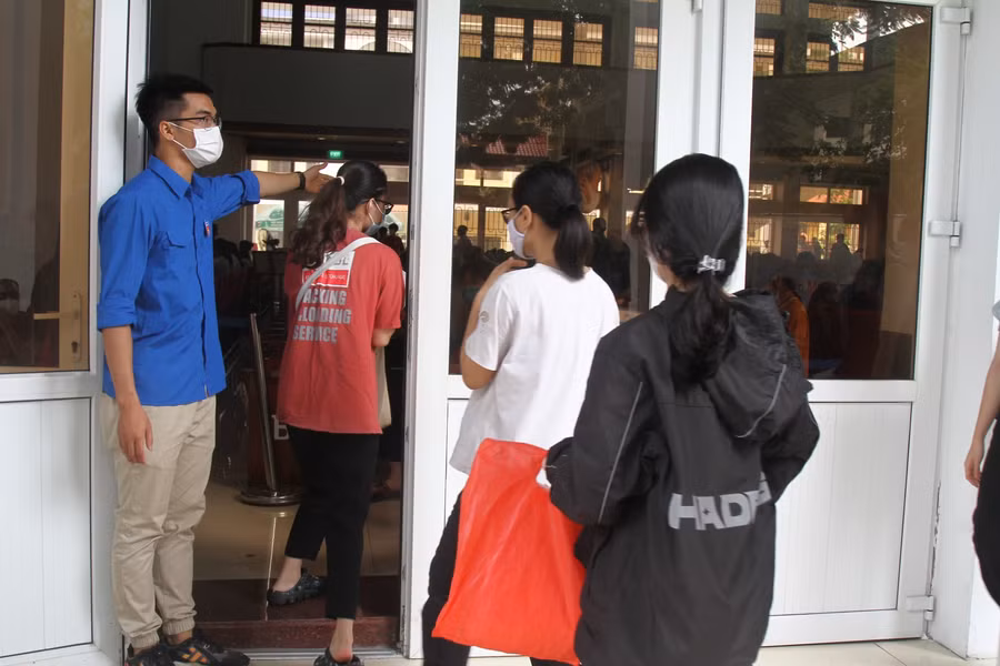 Nguyễn Thành Đạt trong màu áo xanh tình nguyện hướng dẫn tân sinh viên K62, Trường Đại học Hàng hải Việt Nam vào hội trường chờ làm thủ tục