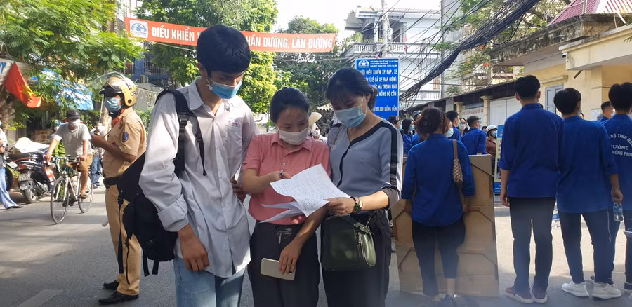 2 cô giáo Trường THPT Lương Thế Vinh nhận xét đề và bài làm cho học sinh ngay tại cổng trường thi