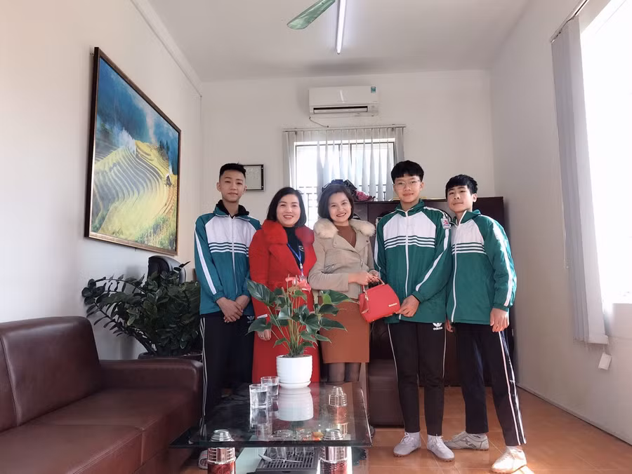 Cô giáo Hoàng Thị Thái Hòa (áo đỏ) cùng 3 HS trao lại túi xách cho người bị mất