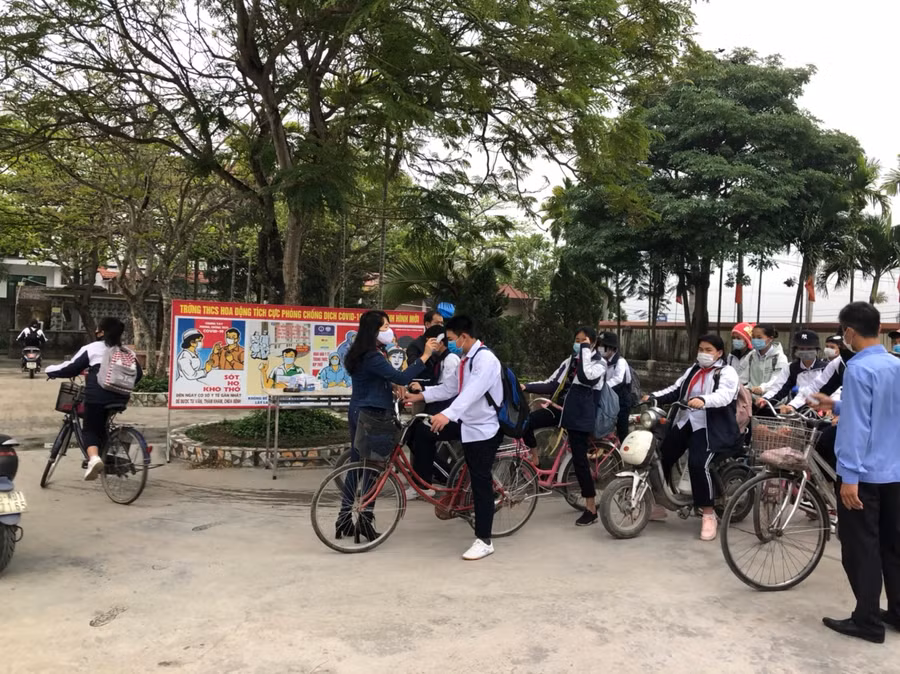 Thầy cô Trường THCS Hoa Động, huyện Thủy Nguyên đo nhiệt độ cho học sinh tại sân trường