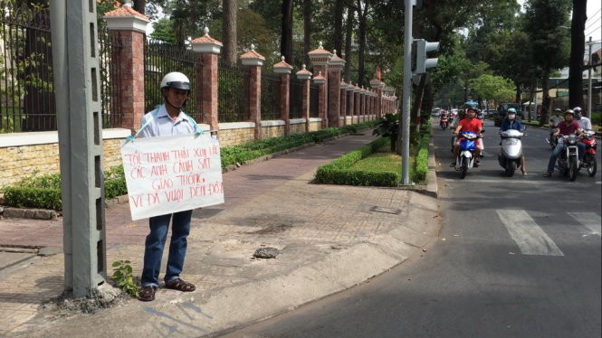 Anh Điền với tấm bảng xin lỗi cảnh sát giao thông trên đường Nguyễn Đình Chiểu, quận 3, TP HCM sáng 12/2.