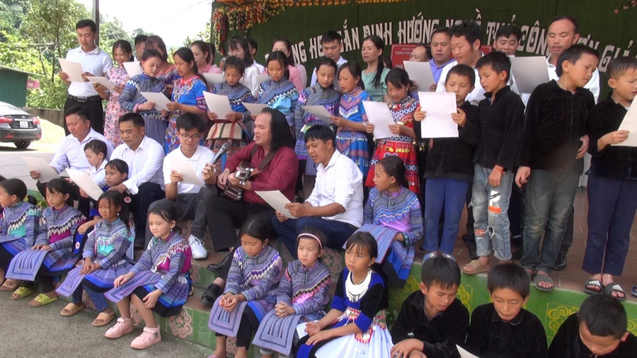 Thầy giáo Trần Phương (người ôm đàn) và Nguyễn Thiên Lương cùng hát ca khúc “Trường em ở bản vùng cao” với học sinh Trường Tiểu học nội trú Simakai (Lào Cai).