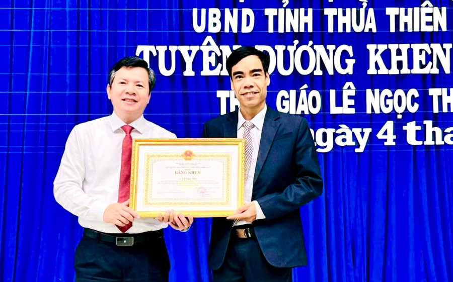 Ông Nguyễn Tân (bên trái) - Giám đốc Sở GD&amp;ĐT tỉnh Thừa Thiên Huế thừa ủy quyền trao Bằng khen của Bộ trưởng Bộ GD&amp;ĐT cho thầy giáo Lê Ngọc Thùy.