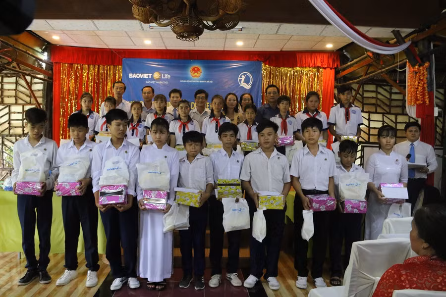 Các em nhận quà và học bổng.