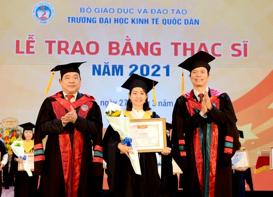 Lãnh đạo Trường Đại học Kinh tế Quốc dân trao giấy khen cho các tân thạc sĩ.