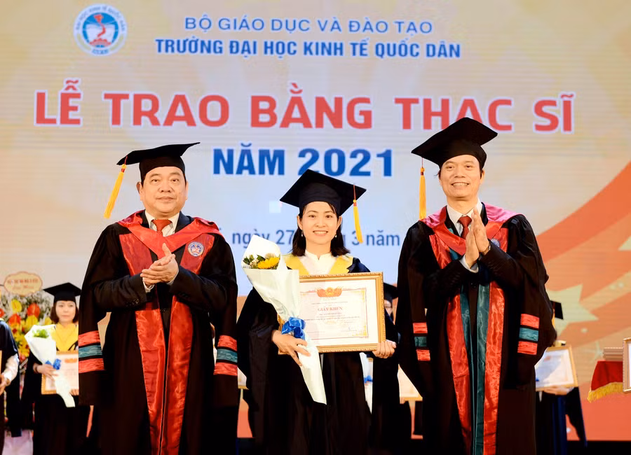 Lãnh đạo Trường Đại học Kinh tế Quốc dân trao giấy khen cho các tân thạc sĩ.