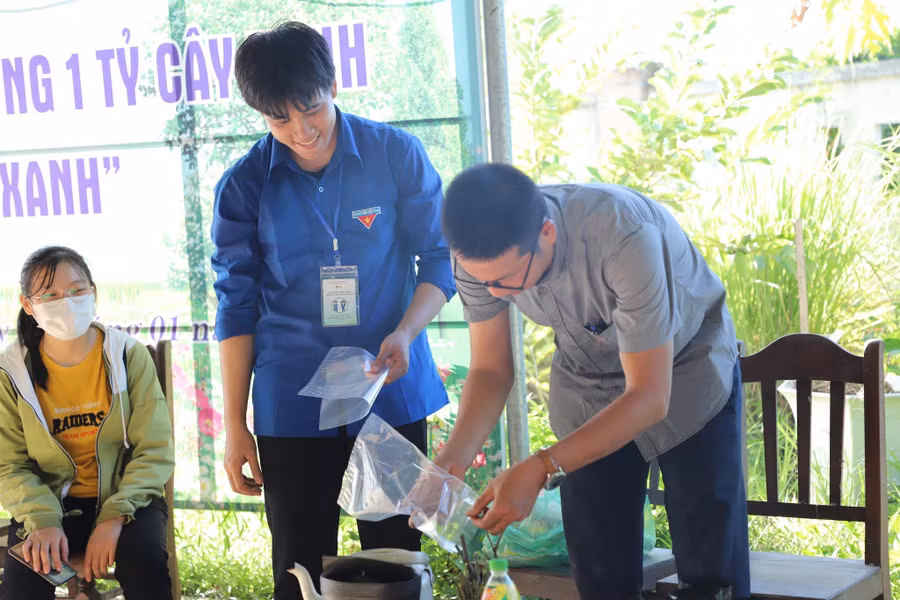 TS Trần Quang Dần (phải) hướng dẫn thanh niên địa phương chăm sóc cây.