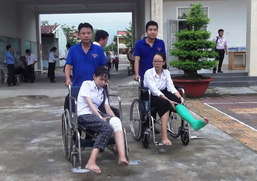 Hai thí sinh ở điểm thi Trường THPT Thới Bình (Cà Mau) bị tai nạn giao thông được tình nguyện viên hỗ trợ suốt kỳ thi.