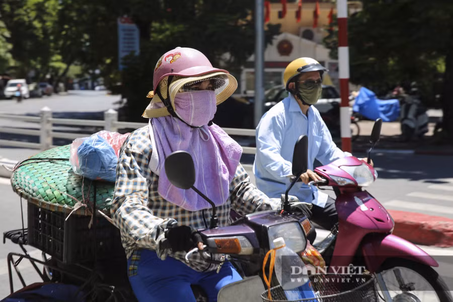 Người dân đi trên đường mặc kín mít từ đầu đến chân để chống lại cái nắng gay gắt.