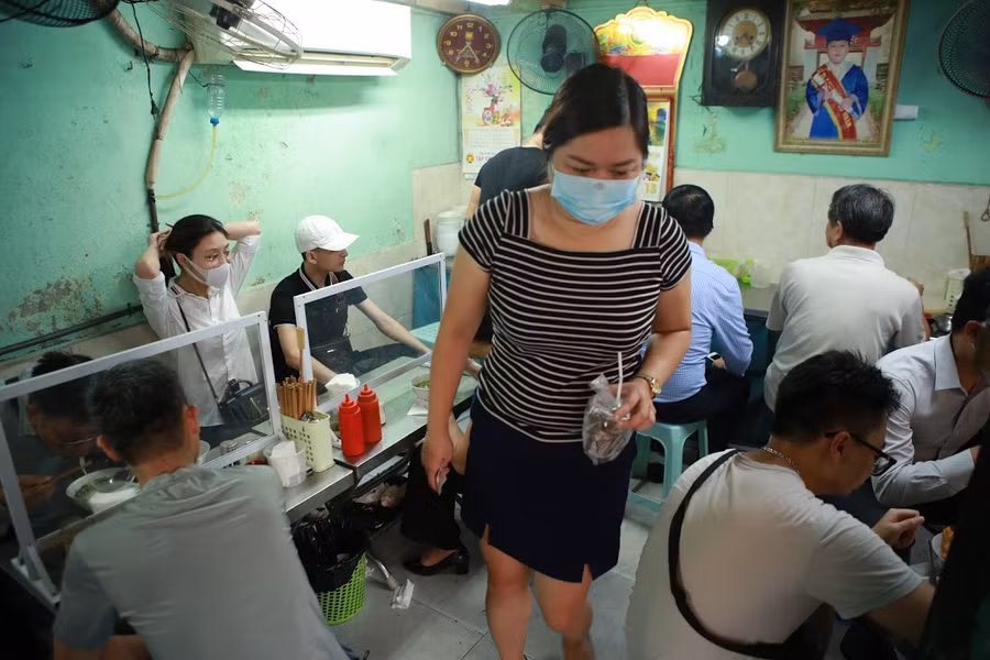 Bên trong cửa hàng ăn, các tấm chắn giữa người với người vẫn được sử dụng để tuân thủ quy tắc phòng chống dịch bệnh Covid-19.