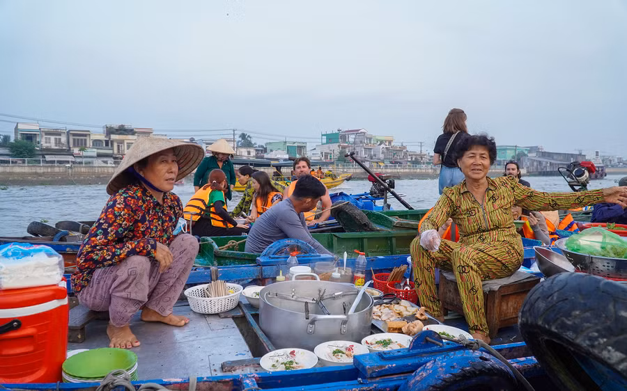 Thương hồ cười vui trong quá trình mua bán tại chợ nổi, thể hiện sự gần gũi và ấm áp của văn hóa miền Tây.