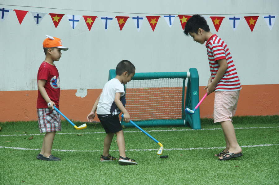Trẻ học chơi Khúc côn cầu. Trong ngày hội, các em được trực tiếp các giáo viên Phần Lan hướng dẫn chơi trò chơi này.