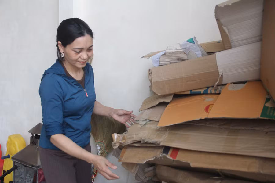 Chị Nguyễn Thị Loan thu gom thêm một số bìa carton tại tiệm hoa để tạo thêm thu nhập cho gia đình.