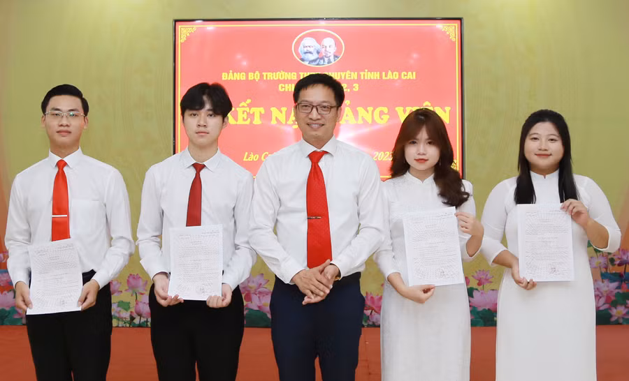 Thầy Ngô Thanh Xuân, Bí thư Đảng bộ, Hiệu trưởng Trường THPT chuyên Lào Cai, trao Quyết định kết nạp đảng viên cho 4 học sinh.