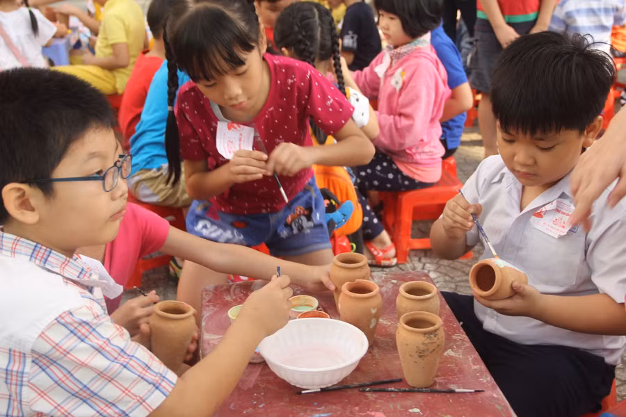 Học sinh tiểu học tham gia trang trí bình hoa trong lễ hội Xuân. Ảnh minh họa 