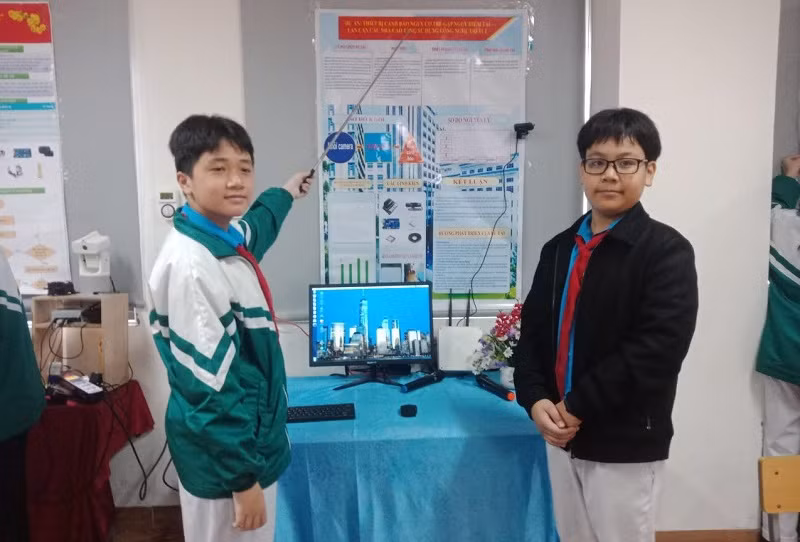 Lưu Tuấn Hưng, Nguyễn Thành Nam bên mô hình “Thiết bị cảnh báo nguy cơ trẻ gặp nguy hiểm tại lan can các nhà cao tầng sử dụng công nghệ trí tuệ nhân tạo”. Ảnh: NTCC