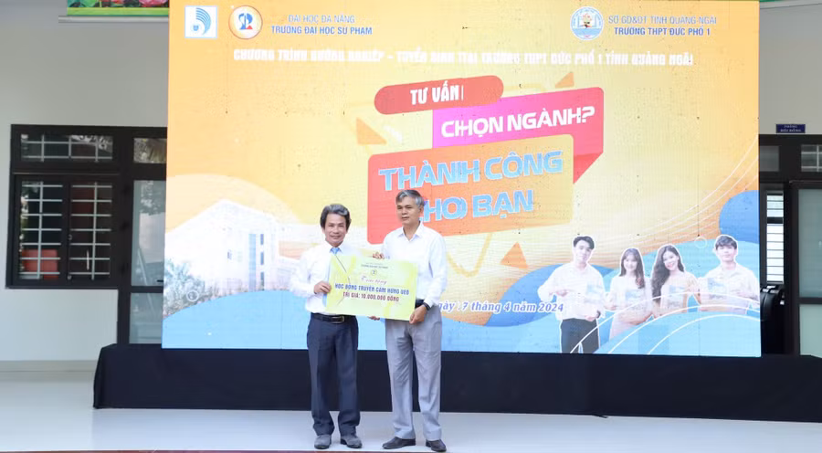 PGS.TS Võ Văn Minh - Hiệu trưởng Trường Đại học Sư phạm, Đại học Đà Nẵng trao học bổng Truyền cảm hứng trong Chương trình Hướng nghiệp - tuyển sinh tại Trường THPT Đức Phổ 1 (Quảng Ngãi). Ảnh: NTCC