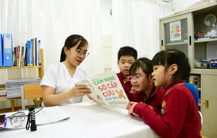 Cô Trần Thanh Thủy, nhân viên y tế Trường Tiểu học Lý Thái Tổ (Hà Nội) hướng dẫn học sinh kỹ năng sơ cấp cứu ban đầu. Ảnh: NTCC