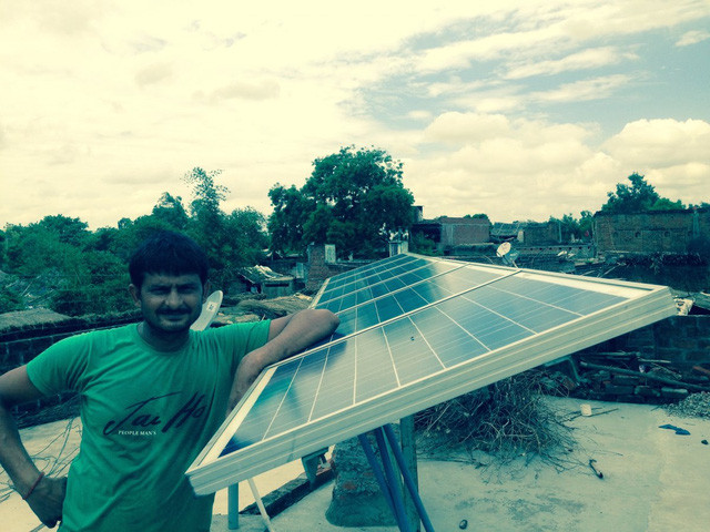 Chủ cửa hàng nạp điện cho đèn bằng tấm năng lượng mặt trời trên mái nhà.