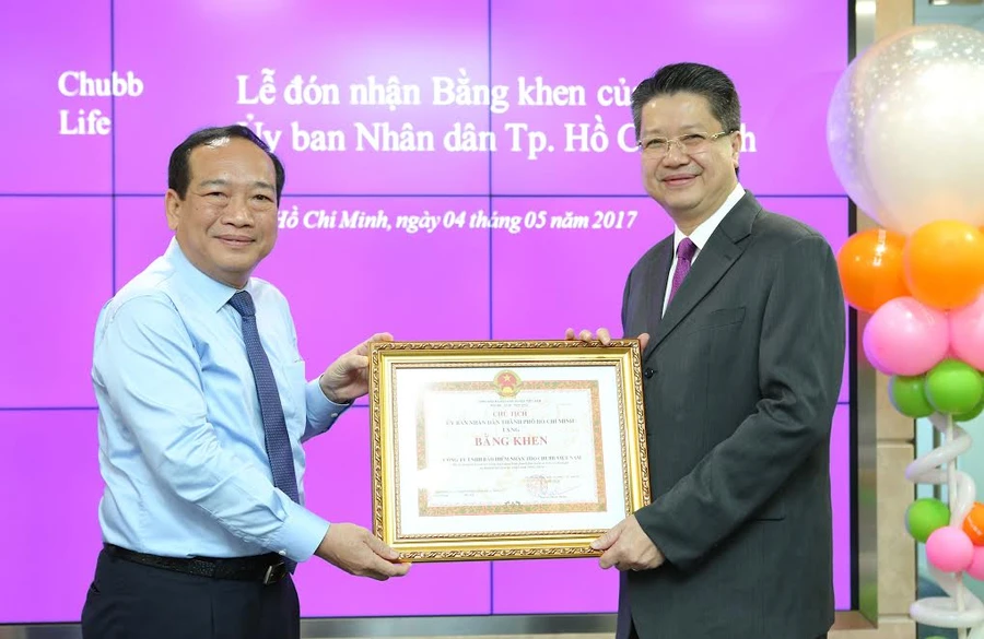 Ông Huỳnh Công Hùng - Trưởng Ban Thi đua - khen thưởng TP.HCM (trái) trao bằng khen của UBND TP HCM cho ông Lâm Hải Tuấn - Chủ tịch Hội đồng Quản trị kiêm Tổng Giám đốc Chubb Life Việt Nam. Ảnh: Tuấn Hùng