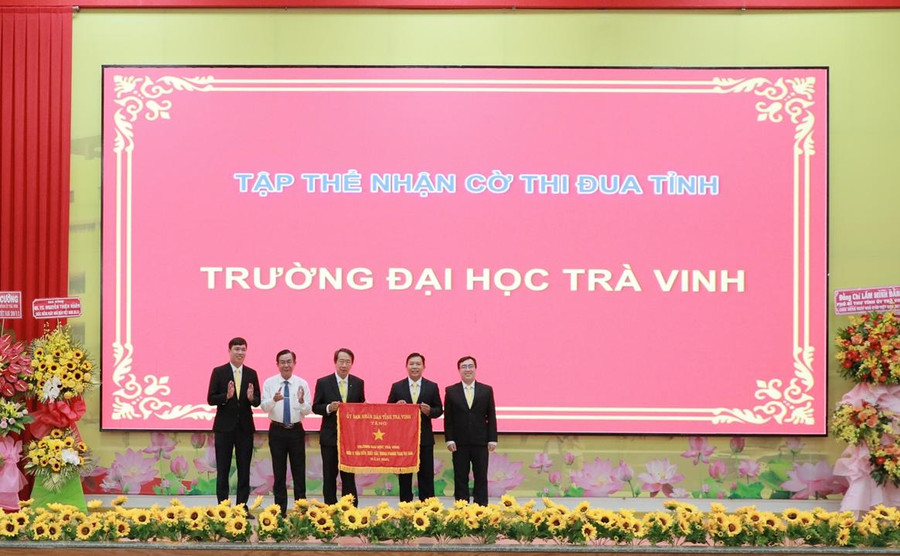 Ông Lê Thanh Bình, Phó Chủ tịch UBND tỉnh Trà Vinh (thứ hai từ trái sang) tặng Cờ thi đua của UBND tỉnh cho Trường ĐH Trà Vinh.
