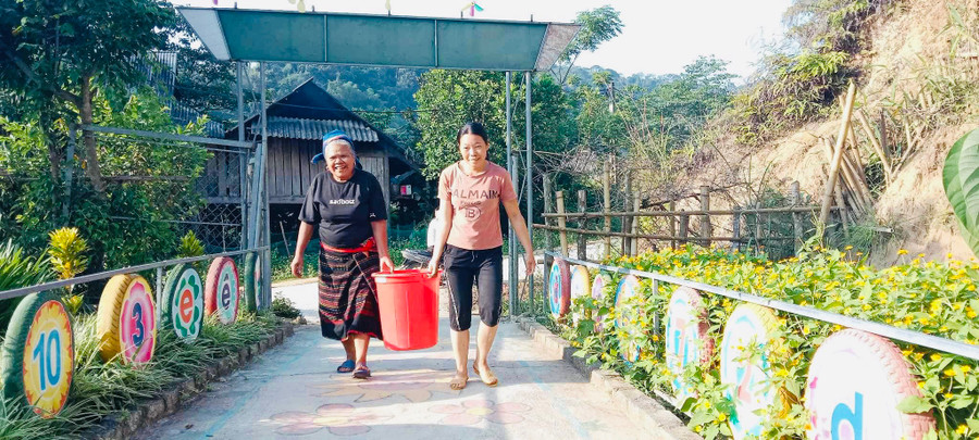 Phụ huynh giúp cô giáo xách nước từ suối về trường Mầm non Nậm Nhoóng, huyện Quế Phong, Nghệ An.