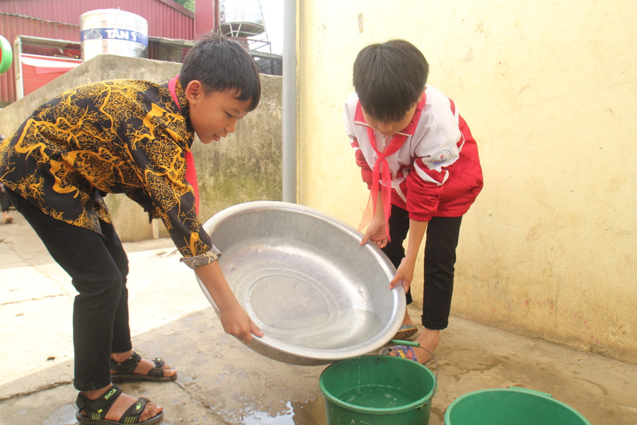 Học sinh Trường PTDTBT Tiểu học Hồng Thu tận dụng nước rửa tay để tưới hoa.