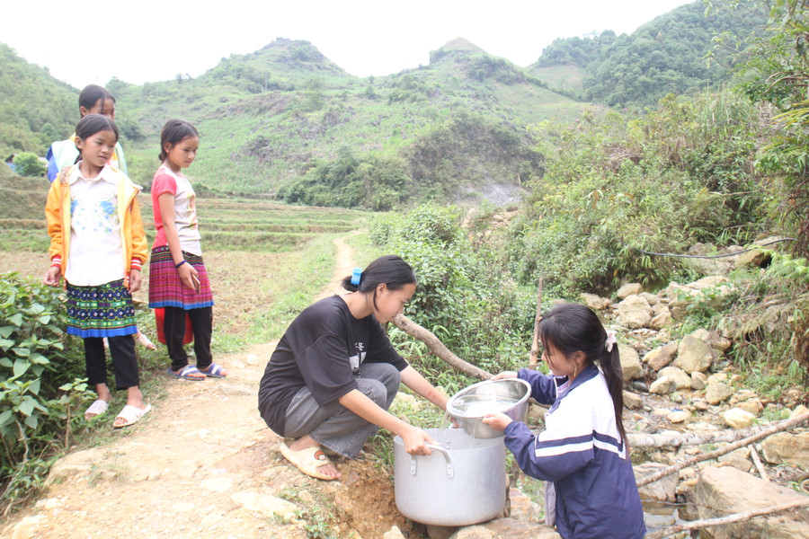 Học sinh Trường PTDTBT THCS Hồng Thu múc nước mang về.