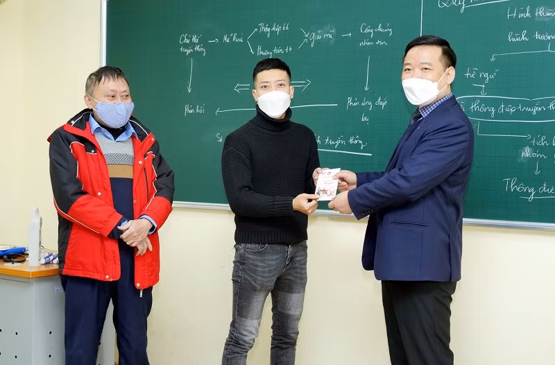 Lãnh đạo Trường ĐH Kinh tế Quốc dân lì xì cho sinh viên trong buổi học trực tiếp đầu tiên sau thời gian dài học trực tuyến.