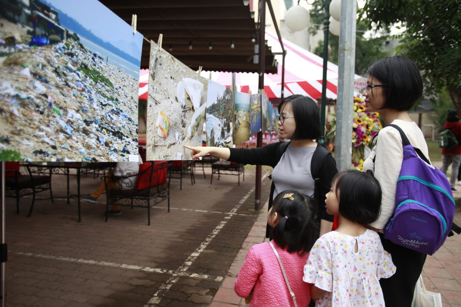 Khách tham dự xem triển lãm ảnh về ô nhiễm rác thải nhựa.