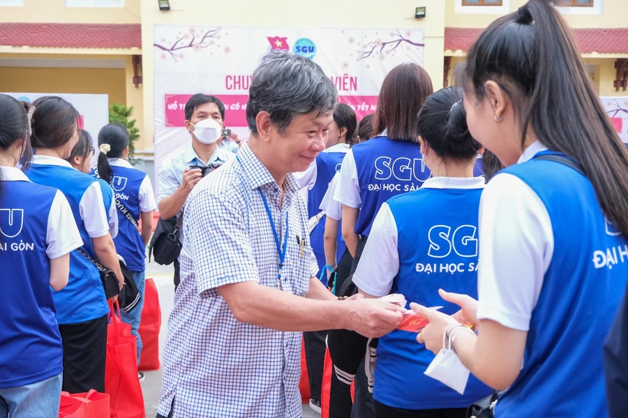 PGS.TS Phạm Hoàng Quân, Hiệu trưởng Trường Đại học Sài Gòn tặng quà trong Chương trình “Chuyến xe Đoàn viên” hỗ trợ sinh viên khó khăn về quê đón Tết Nguyên đán năm 2023. Ảnh: SGU