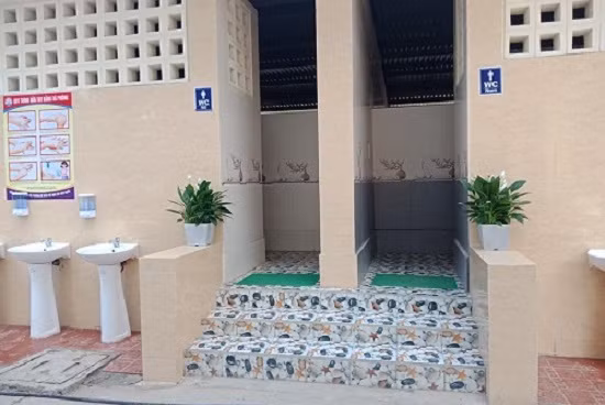 Với mục tiêu xây dựng “Nhà vệ sinh thân thiện”, tất cả khu vực xung quanh các nhà vệ sinh được đổ bê tông cao ráo. Phía tường ngoài được lắp các bồn rửa tay, có gắn hộp đựng nước rửa tay để các em rửa tay, rửa mặt trước và sau khi ăn hoặc khi ngủ dậy.