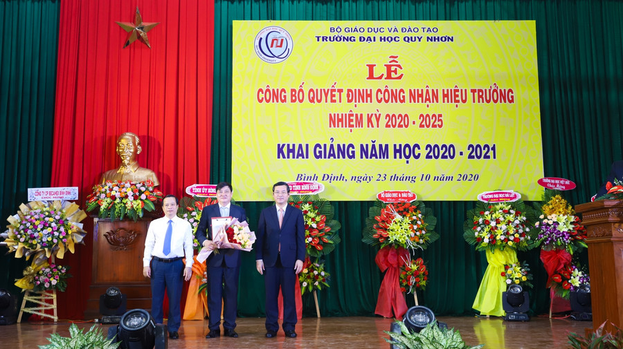 Thứ trưởng Bộ GD&ĐT Nguyển Văn Phúc và Phó chủ tịch UBND tỉnh Bình Định Nguyễn Tuấn Thanh trao quyết định và tặng hoa cho Hiệu trưởng.