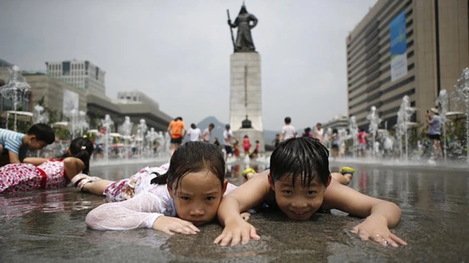 Trẻ em Hàn Quốc chơi ở một đài phun nước tại Seoul. Ảnh: Reuters