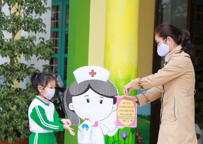 Giáo viên Trường Mầm non Bảo Ninh hướng dẫn học sinh việc sử dụng dung dịch sát khuẩn.